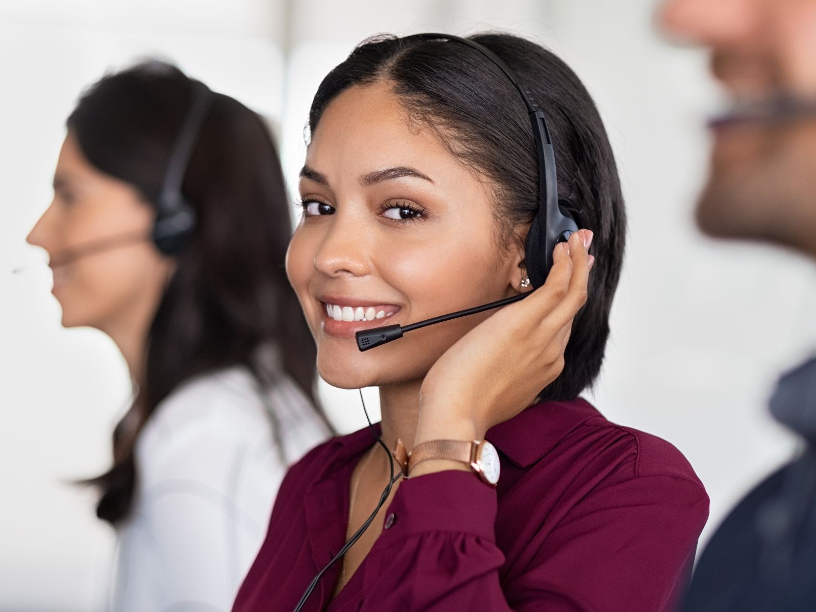 Operadora de call center sonriendo y usando un headset, representando el personal calificado reclutado para centros de contacto.