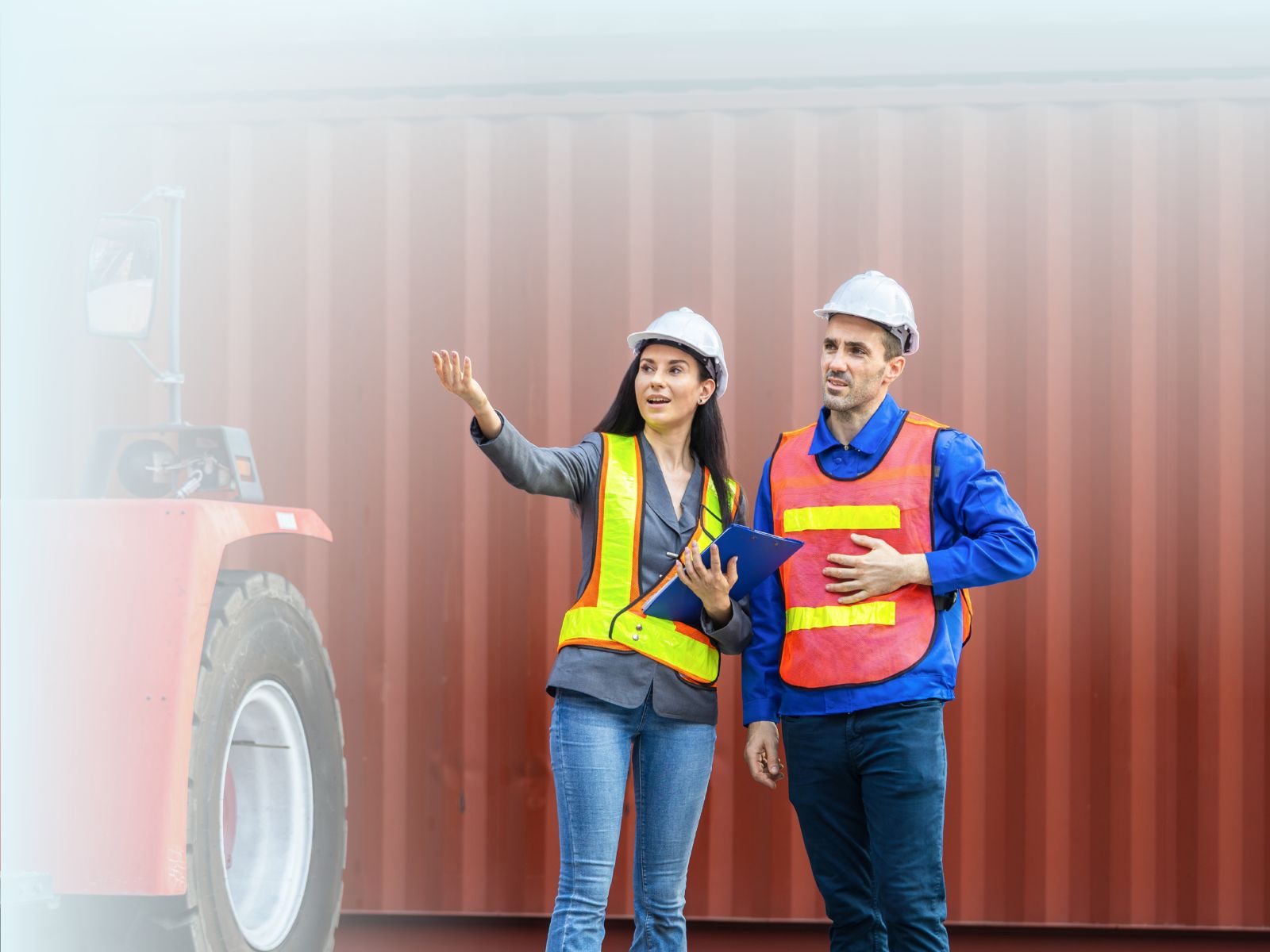 Ingeniera de logística y operador con chalecos de seguridad, coordinando el manejo de contenedores en un puerto de carga.