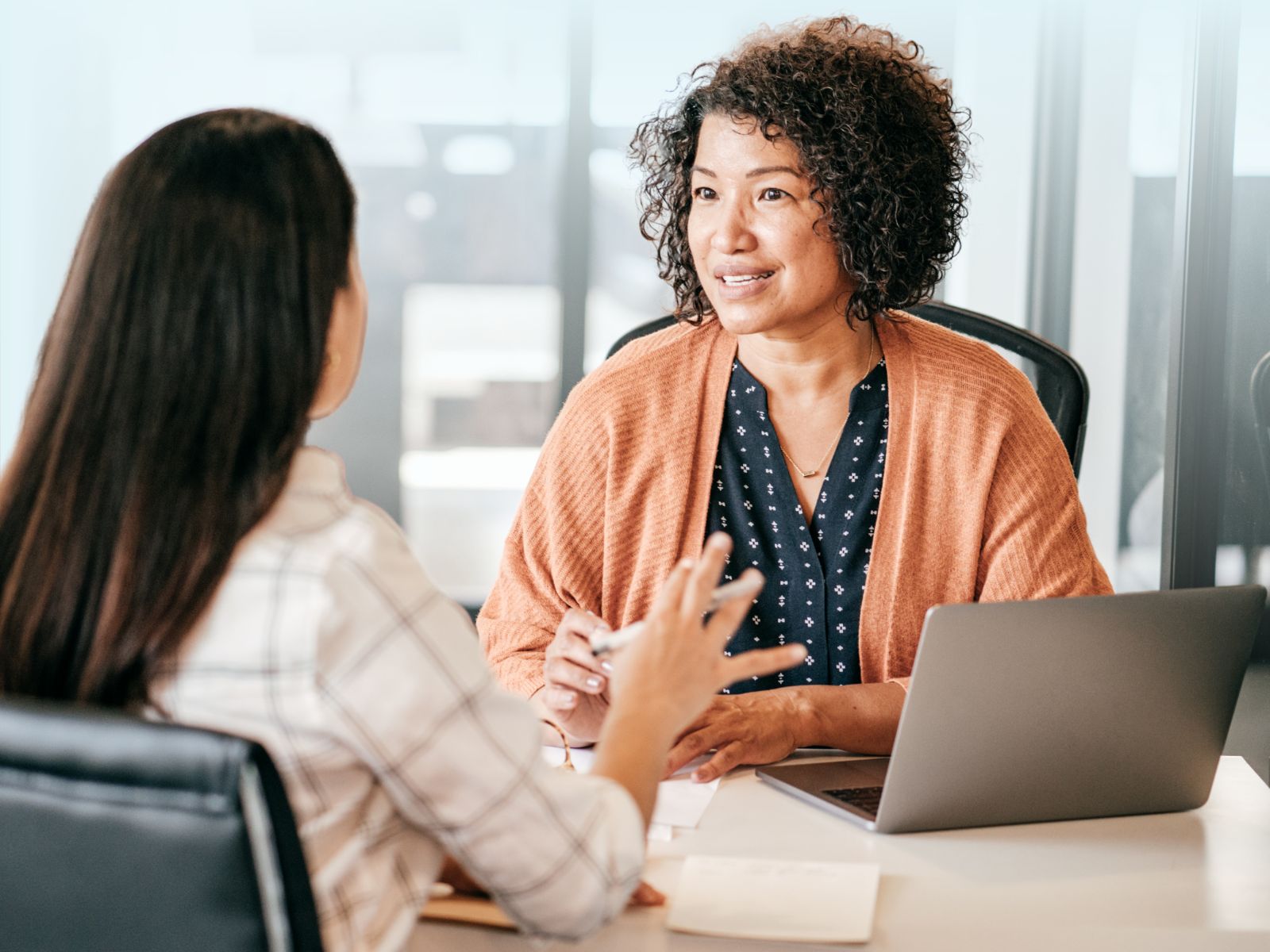 Consultora de recursos humanos asesorando a un cliente sobre el reclutamiento masivo para la contratación de personal especializado.