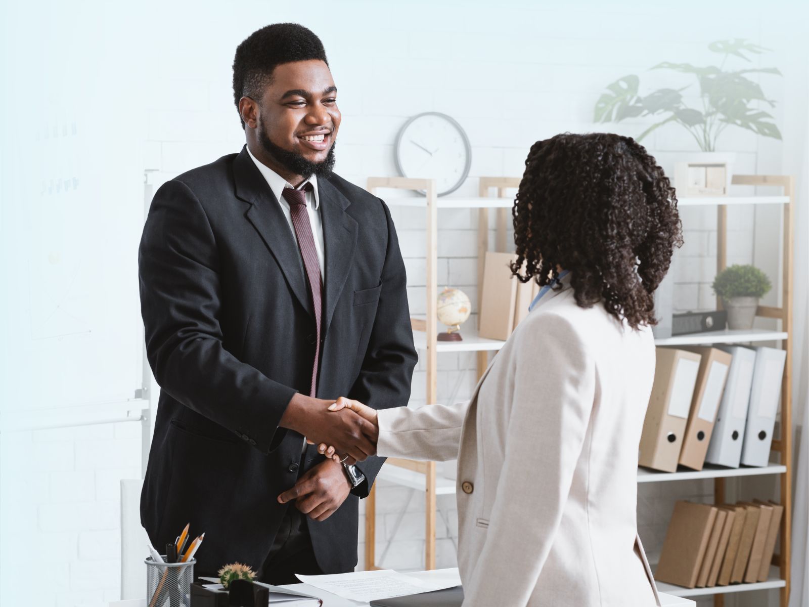 Apretón de manos entre un ejecutivo y un candidato, celebrando una contratación exitosa tras un proceso de reclutamiento y selección.