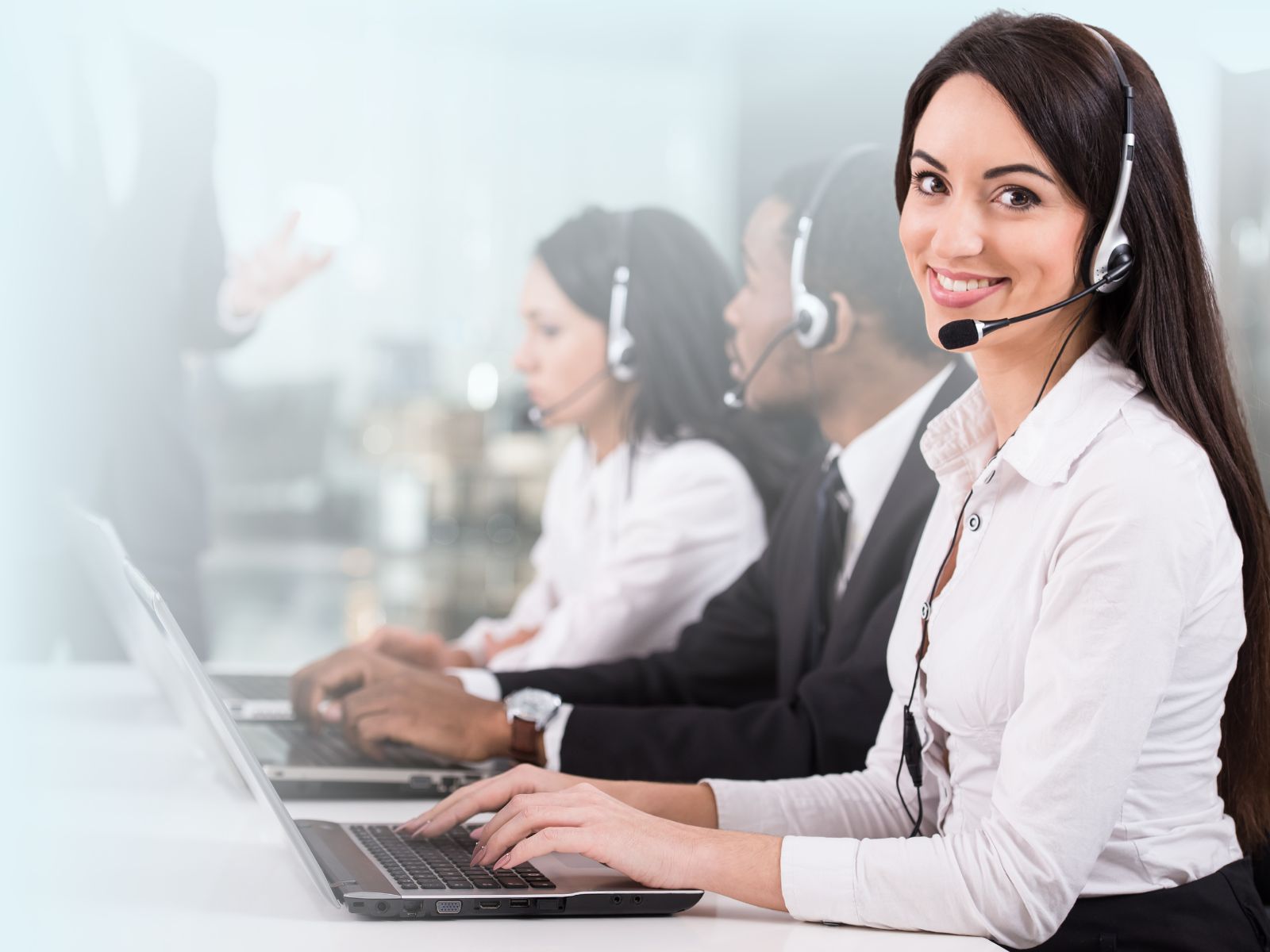 Operadora bilingüe de call center en Puebla sonriendo con equipo de diademas telefónicas, representando el talento calificado de Reclutamiento 3R.