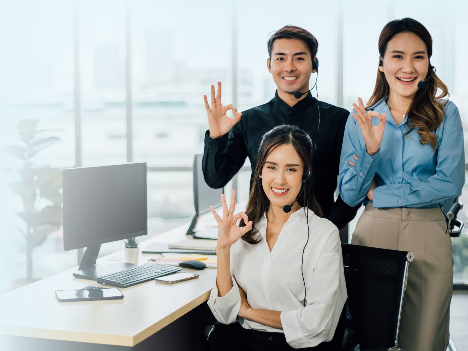 Equipo de agentes bilingües de Call Center en Tijuana haciendo la señal de aprobación, representando el talento calificado de Reclutamiento 3R.