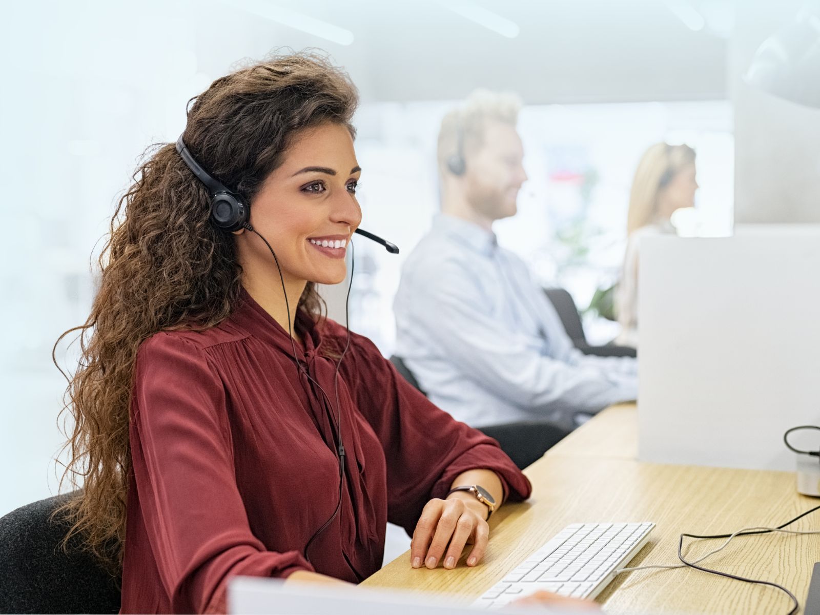Agente telefónica bilingüe seleccionada por Reclutamiento 3R operando con diadema y equipo de cómputo en un call center de la CDMX.